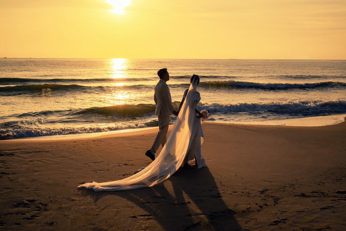 Pareja caminando por la playa al atardecer